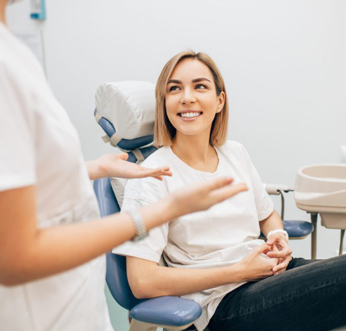Smiling woman receiving dental treatment from dentist in modern clinical office setting.